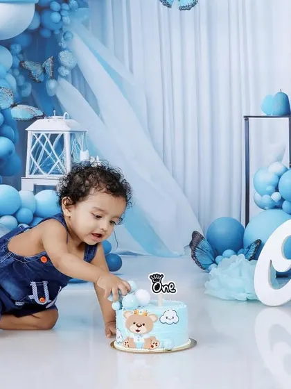 Here we go! Capturing the first touch of the cake is a key moment in any cake smash session. This action shot shows Naksha's curiosity as he reaches for his birthday treat.