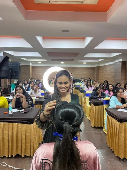 A trainer demonstrating hairstyling techniques to an engaged audience in Bangalore.