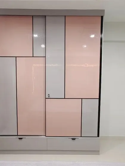 A closer look at the pastel pink and grey wardrobe, highlighting the fluted glass section that provides a glimpse of the items inside while maintaining a sense of privacy.