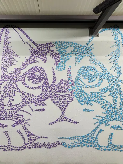 A detailed view of the cat mural at Chasing Tails. The use of two-toned, heart-shaped MDF cutouts gives the artwork a distinct pixelated style that is both modern and playful.