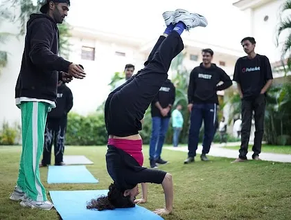 A participant at our Polkadot corporate event nails a headstand. We love helping teams step out of their comfort zones and achieve things they didn't think were possible.