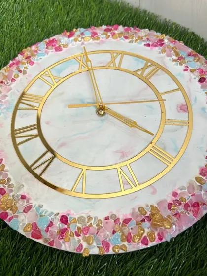 A vibrant and colorful clock with a multi-colored crystal border in shades of pink, blue, and gold.