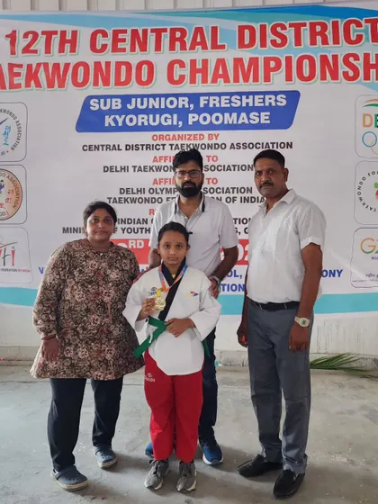 A student receives her Poomsae Gold medal at the 12th Central District Taekwondo Championship.
