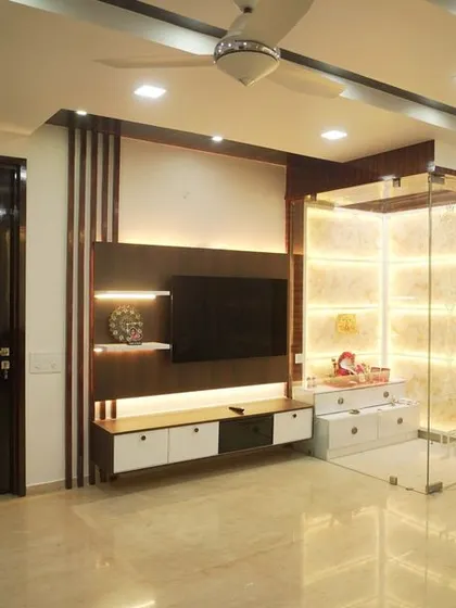 A wide shot of the integrated TV and pooja unit, showcasing how we blend entertainment and spirituality into a single, cohesive wall feature. The dark wood and bright lighting create a stunning contrast.