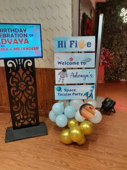 A custom welcome sign for the "Space Tacular Party," complete with planet cutouts and a balloon cluster. It's all in the details.