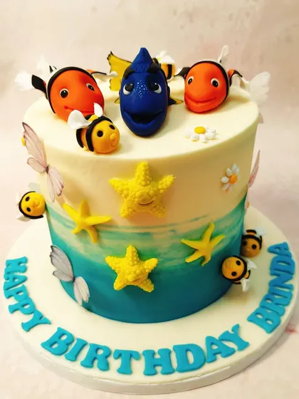 We just keep swimming with this delightful Finding Dory cake. The design features an ocean-blue ombre effect, with Dory, Nemo, and friendly bees creating a whimsical "surf and turf" scene that is both unique and playful.
