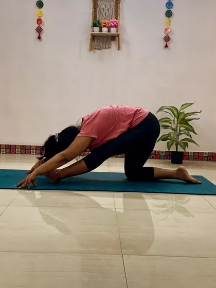 A client in Ardha Hanumanasana (Half Splits), a preparatory pose for the full splits that provides a deep stretch for the hamstrings and hips.