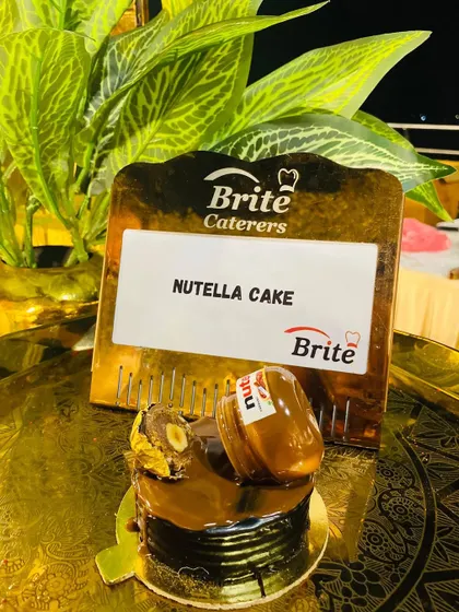 An individual Nutella Cake, topped with a miniature Nutella jar and a Ferrero Rocher.