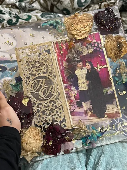 This large resin block preserves a couple's intricate wedding invitation alongside their photo and flowers from their special day. The mix of different colored flowers and gold leaf creates a rich, celebratory feel.