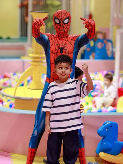 The birthday boy gives a thumbs-up next to his hero, Spider-Man, in our colorful ball pit area. It's a perfect photo that captures the excitement of the day.