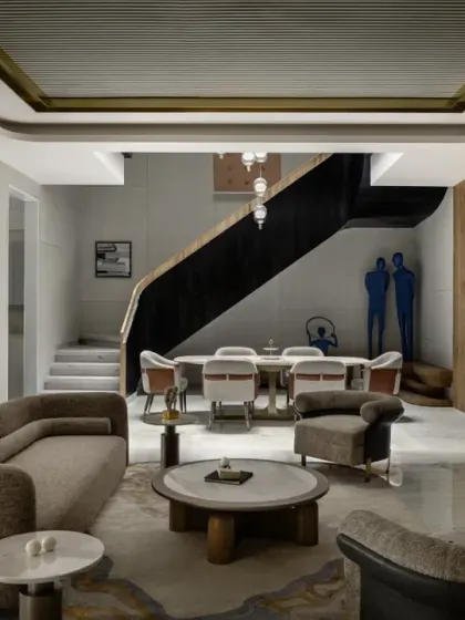 This wide view of the ground floor at The House of Dancing Screens shows the open-plan layout. The formal lounge, drawing room, and dining area are all connected, with the triple-height space above creating a sense of grandeur and openness.