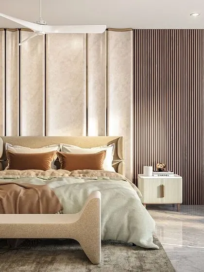 A bedroom design for the Jammu residence, showcasing a harmonious blend of textures. A padded headboard is flanked by fluted wood paneling, creating a space that feels both modern and warm.