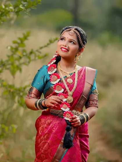 A beautiful outdoor bridal portrait, with the bride looking up thoughtfully, her traditional attire complemented by the natural background.