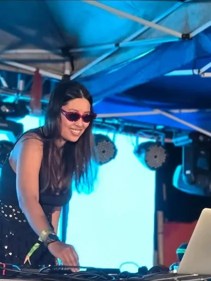 In my element, mixing tracks under the bright lights of an outdoor festival stage. This is a glimpse of my setup and focus during a high-tempo set, ensuring a seamless flow of music for the party.