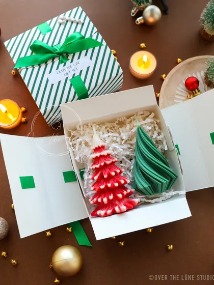 A bold and modern Christmas gift set, with red and green abstract tree candles. The accordion-style box makes for a fun unboxing experience.