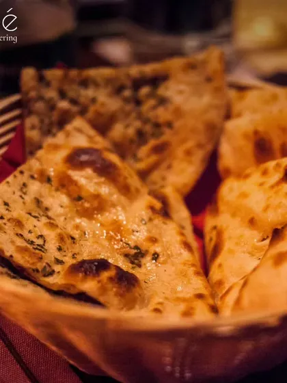 A basket of freshly baked naan bread. We believe no Indian meal is complete without a selection of soft, fluffy breads, served hot from the tandoor.