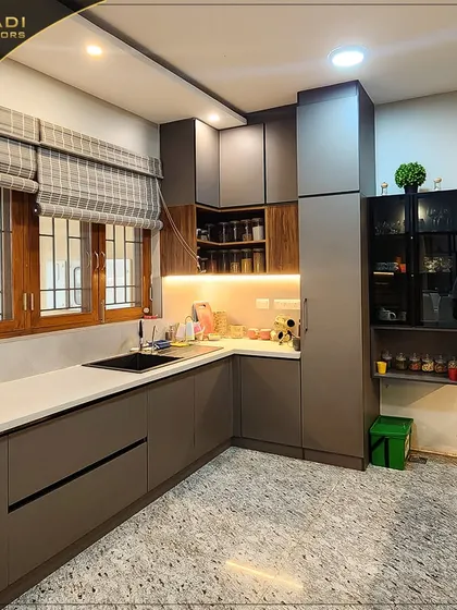 A compact and efficient kitchen with matte-finish grey cabinets and a terrazzo-style floor. The design includes open shelving for spices and a smart layout for a small space.