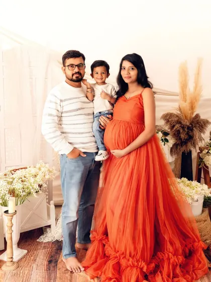 A complete family portrait glowing with happiness. This studio maternity shoot captures the warmth and love of a family eagerly awaiting their newest addition.