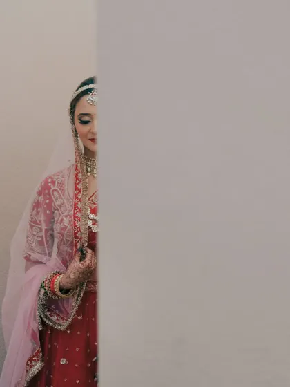 A playful, hide-and-seek portrait of the bride peeking out from behind a wall. This image is creative and artistic, showing a different side of bridal photography.