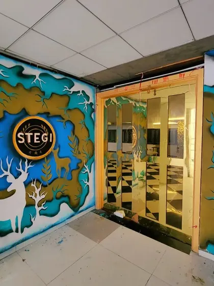 A wider view of the entrance, showing how the mural wraps around the corner and leads guests inside.