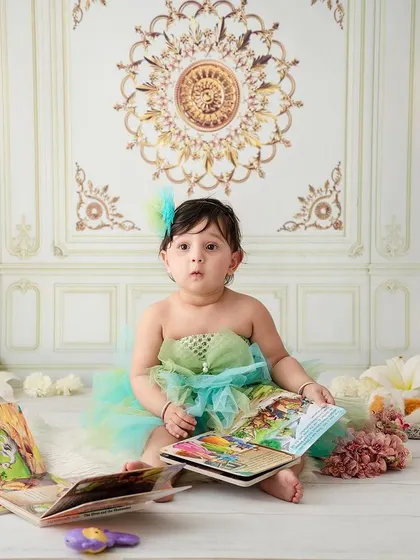 Study time. This little girl looks up from her book with a curious expression, a sweet moment from a classic studio session.