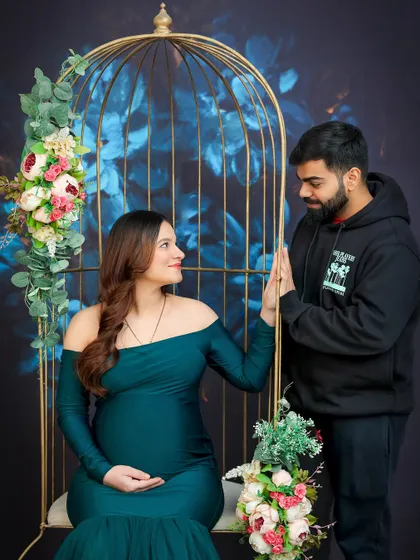 A quiet, connected moment between the couple, framed by our elegant birdcage prop. The dark, floral background adds a touch of artistic drama.