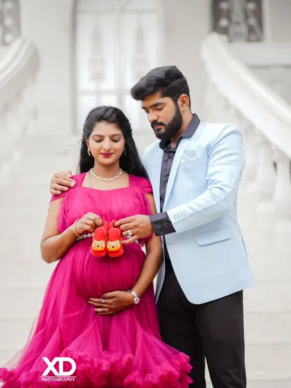 A sweet photo of a couple holding tiny baby shoes together, symbolizing their shared excitement.