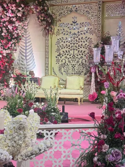 A detail shot of the stage decor, highlighting the candelabras and the beautiful textures of the floral pillars.