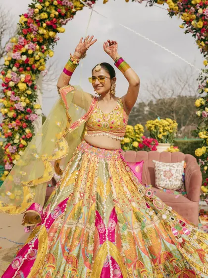 A Haldi ceremony is all about joy and color. For this bride, we chose a vibrant, multi-hued lehenga that was as playful and full of life as the celebration itself, complete with fun sunglasses for a modern twist.
