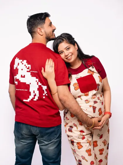 A cute pose showing off the fun graphic on the dad-to-be's t-shirt, adding a personal and playful element to the shoot.