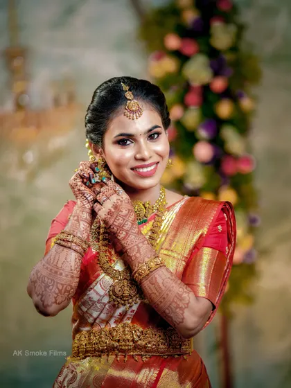 A radiant South Indian bride from Tirupur, her smile lighting up the frame as she adjusts her traditional jewelry.