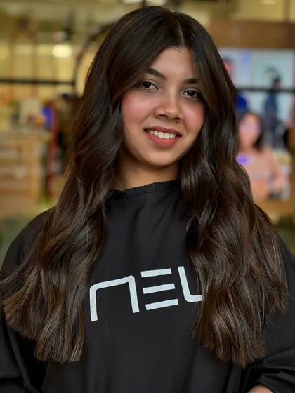 This frontal view shows how the balayage brightens up her overall look. The placement of the highlights around the face is key to this flattering effect.