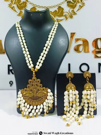Another view of the unique golden and floral jewellery combination. The large peacock-inspired pendant is a true statement piece.