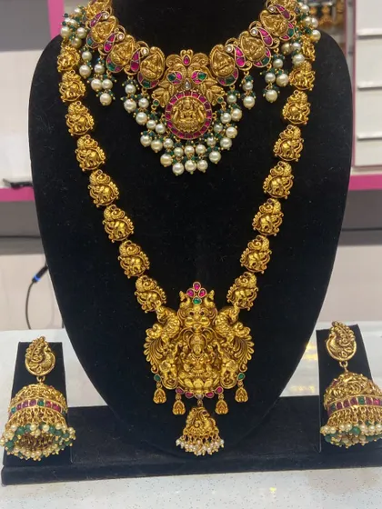 A complete Lakshmi temple jewellery set, including a choker, haram, and matching jhumkas. The antique gold finish gives it a timeless, heritage feel.