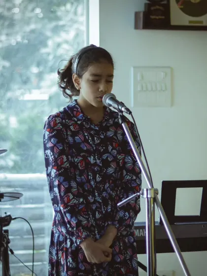 A young vocalist singing with emotion and focus. Our recitals are a celebration of the musical journey and hard work of each student.