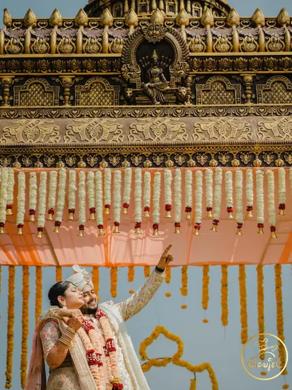 A romantic moment between the couple under the intricately designed roof of their wedding mandap.