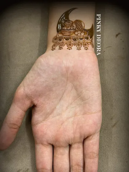 A minimal Karwa Chauth design on the wrist, featuring the crescent moon and a thali (plate). It's a perfect choice for those who prefer subtle yet meaningful art.