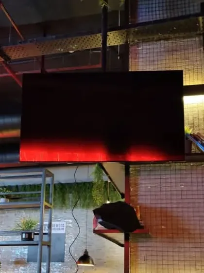 The same display at BrewDog before being powered on. We focus on clean cable management and sturdy mounting, even in complex industrial-style interiors with exposed pipes and metalwork.
