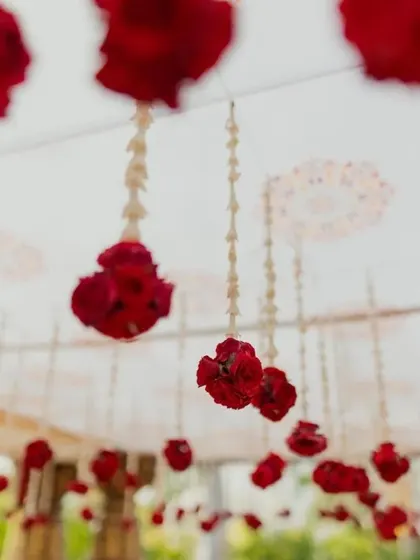 Hanging strings of red rosebuds and jasmine, a classic detail in traditional South Indian wedding decor.