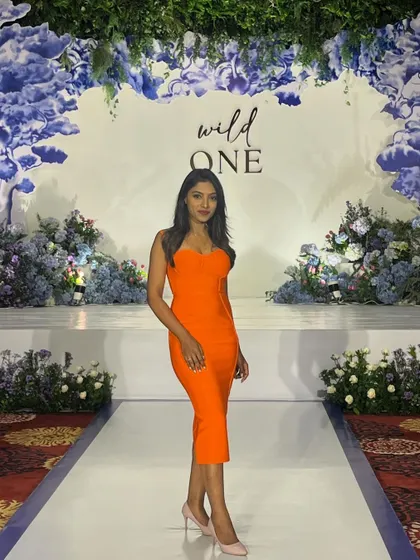 A full-length view of my vibrant outfit and the stunning floral decor at the 'Wild One' birthday party.