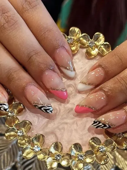 A trendy and bold nail art design combining zebra print, hot pink, and gold glitter lines.