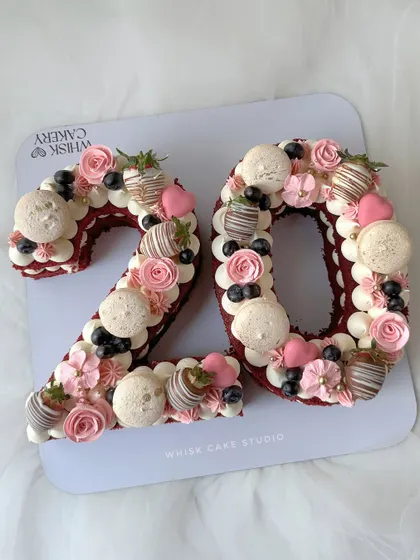 A modern take on birthday cakes. These number or monogram cakes are a unique way to celebrate, decorated with macarons, strawberries, and flowers.