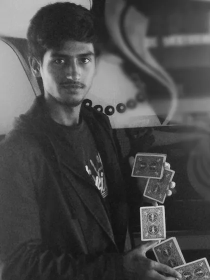 Behind every simple trick are hours of practice. This shot captures a moment of cardistry, the art of flourishing cards, which is a fundamental skill for any sleight of hand artist.
