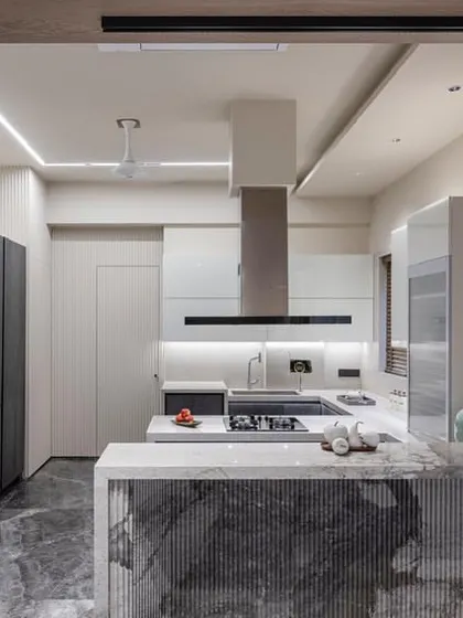 My expertise goes beyond wardrobes. Here is an open-concept kitchen that seamlessly connects to the living area. I used a mix of dark ceramic-finish cabinets and a fluted stone island to create a functional and social heart of the home.