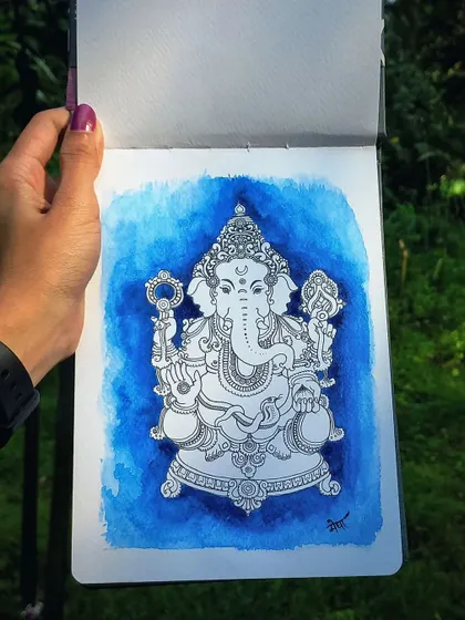 A detailed ink drawing of Lord Ganesha, with a deep blue watercolor wash in the background. This piece was sketched outdoors, surrounded by nature, which always inspires my spiritual art.
