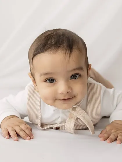 A soft, engaging smile. This close-up shot on a simple white background is all about his sweet expression.