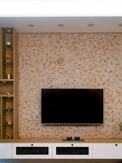 This TV unit is designed to be a feature, not just a utility. The large scale, textured wallpaper background, and clean lines of the console help it blend beautifully with the living room decor while providing ample storage.