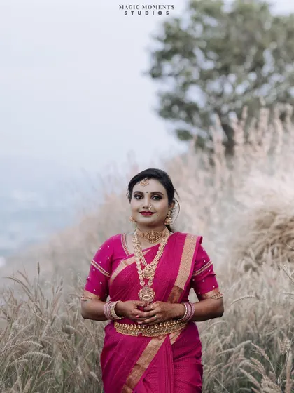 A stunning full-length portrait of the bride standing in a field of tall grass, looking elegant and serene.