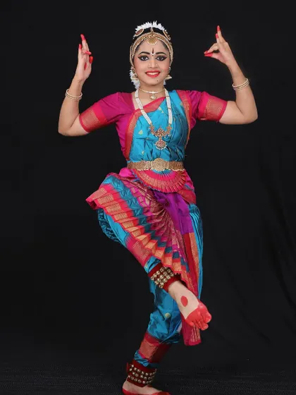 Niyati holding the classic Shiva pose, representing the lord holding the deer and axe. This pose requires great balance and strength.