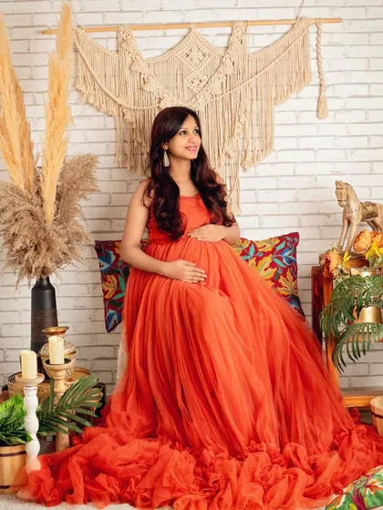A beautiful solo portrait showcasing the full flow of the orange gown in our popular boho-chic setting.